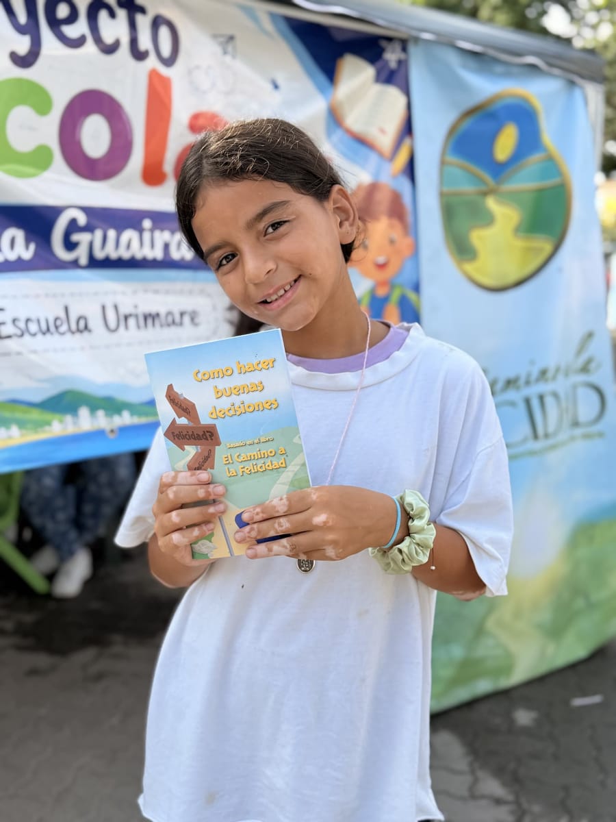 Una niña de la Escuela Urimare muestra su librito